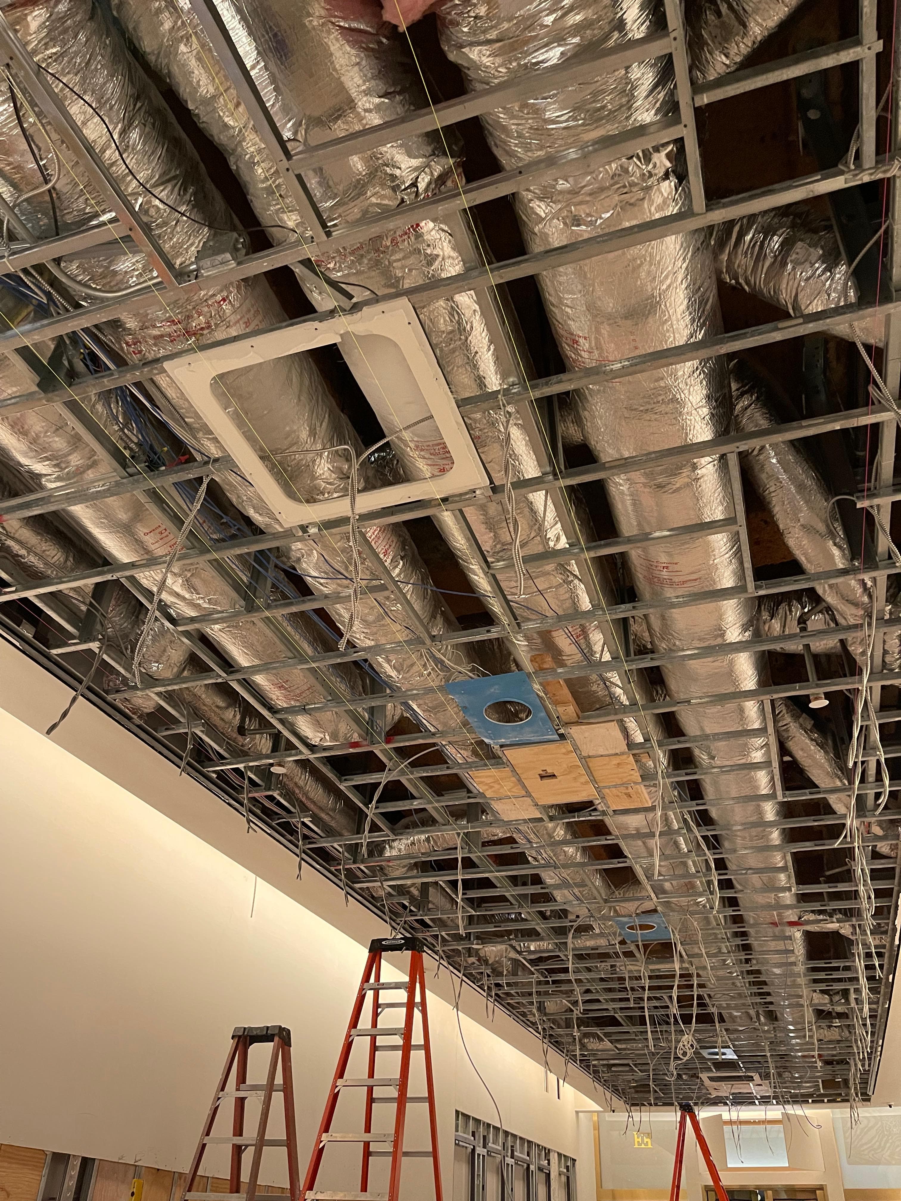 Exposed ceiling infrastructure and ductwork during an active commercial build-out
