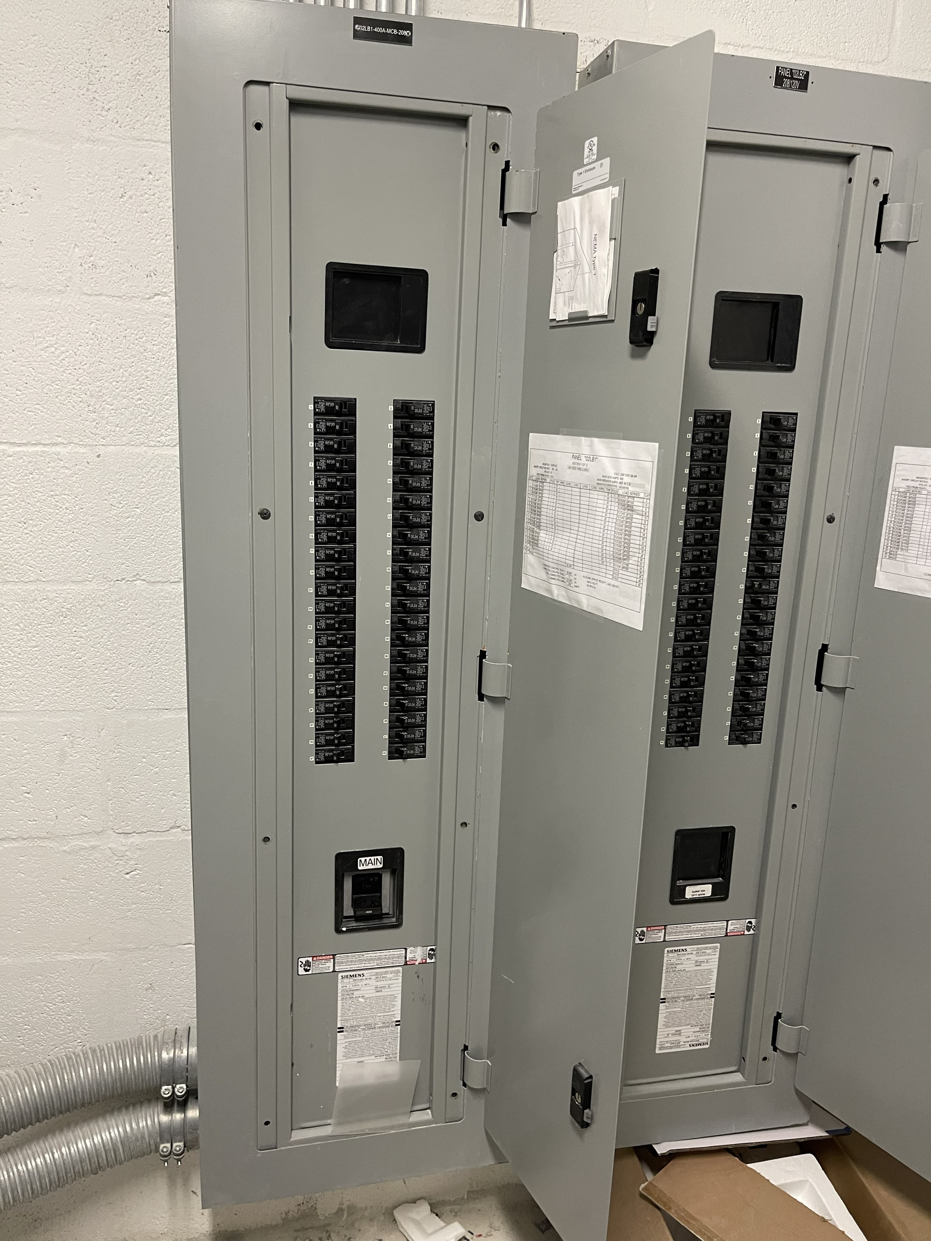 Open commercial electrical panelboards with breaker rows and circuit directories