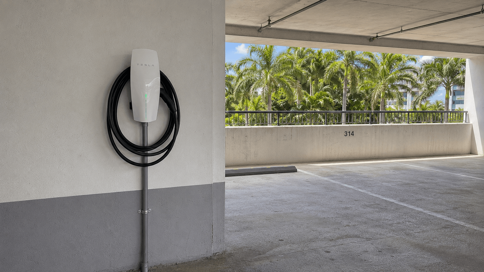 Tesla Wall Connector mounted on a concrete column in a covered condominium parking structure