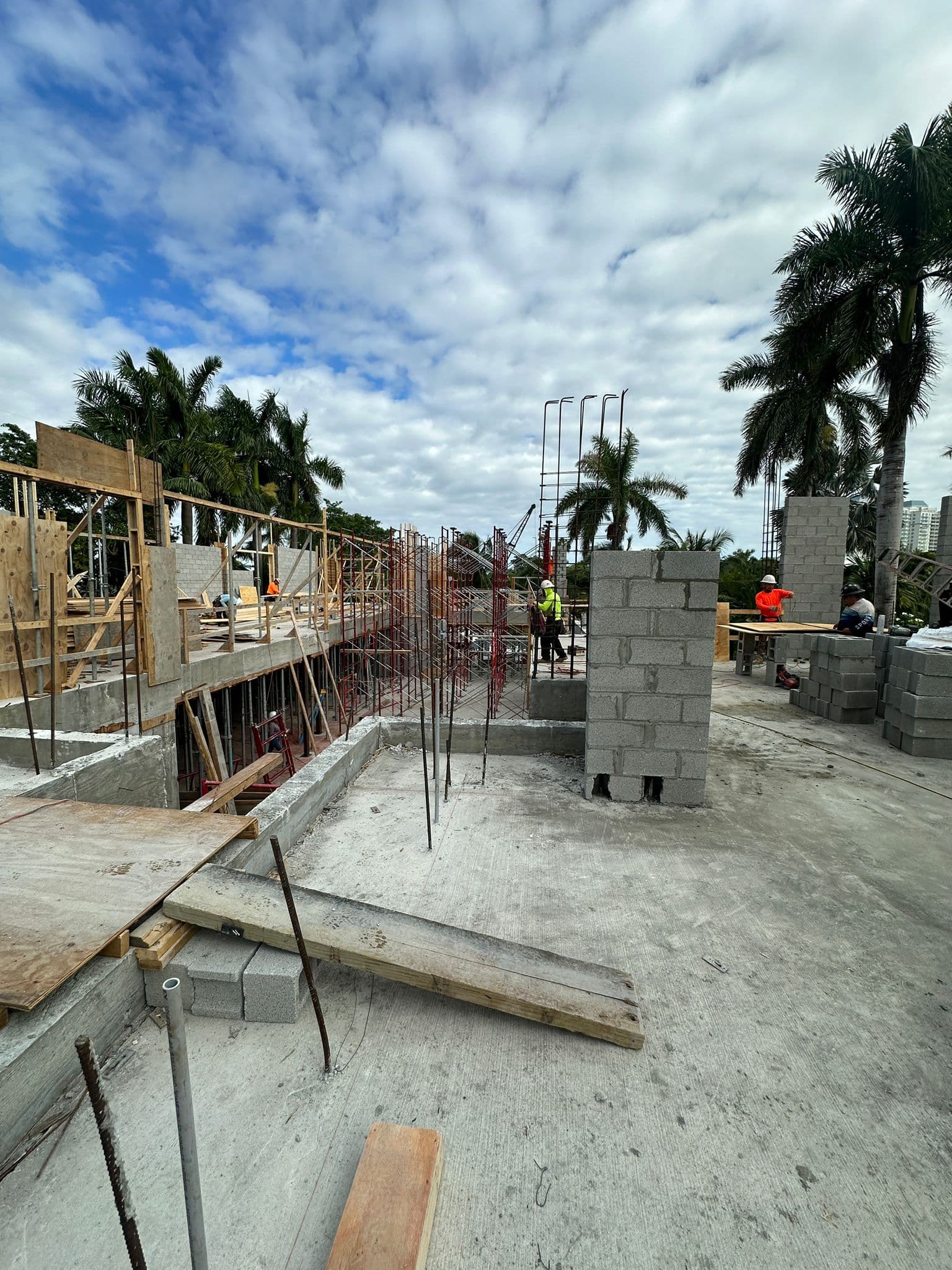 Structural block and rebar construction with workers on an upper level of a new residential building