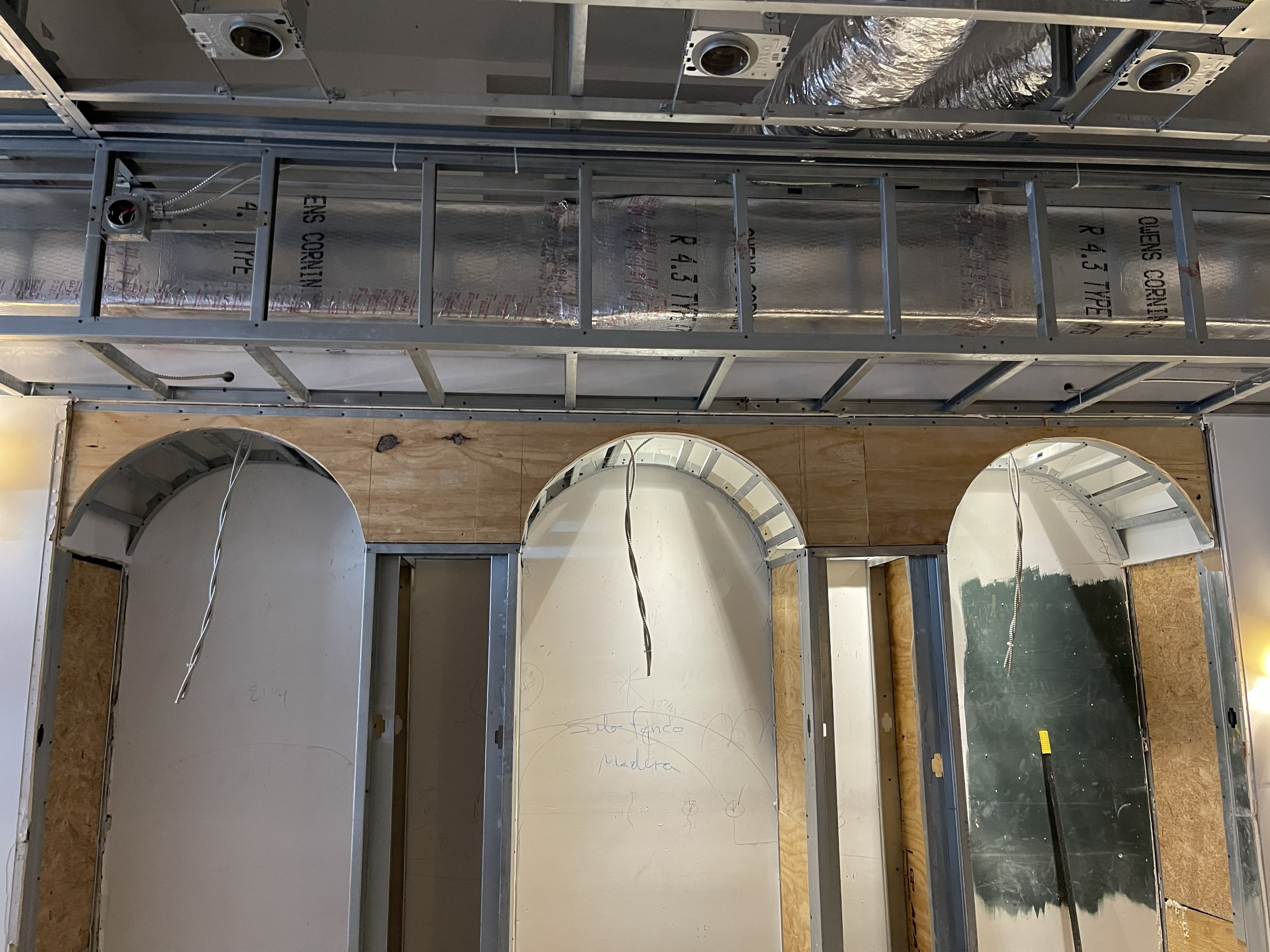 Framed archways and ceiling grid in a retail space mid-build-out