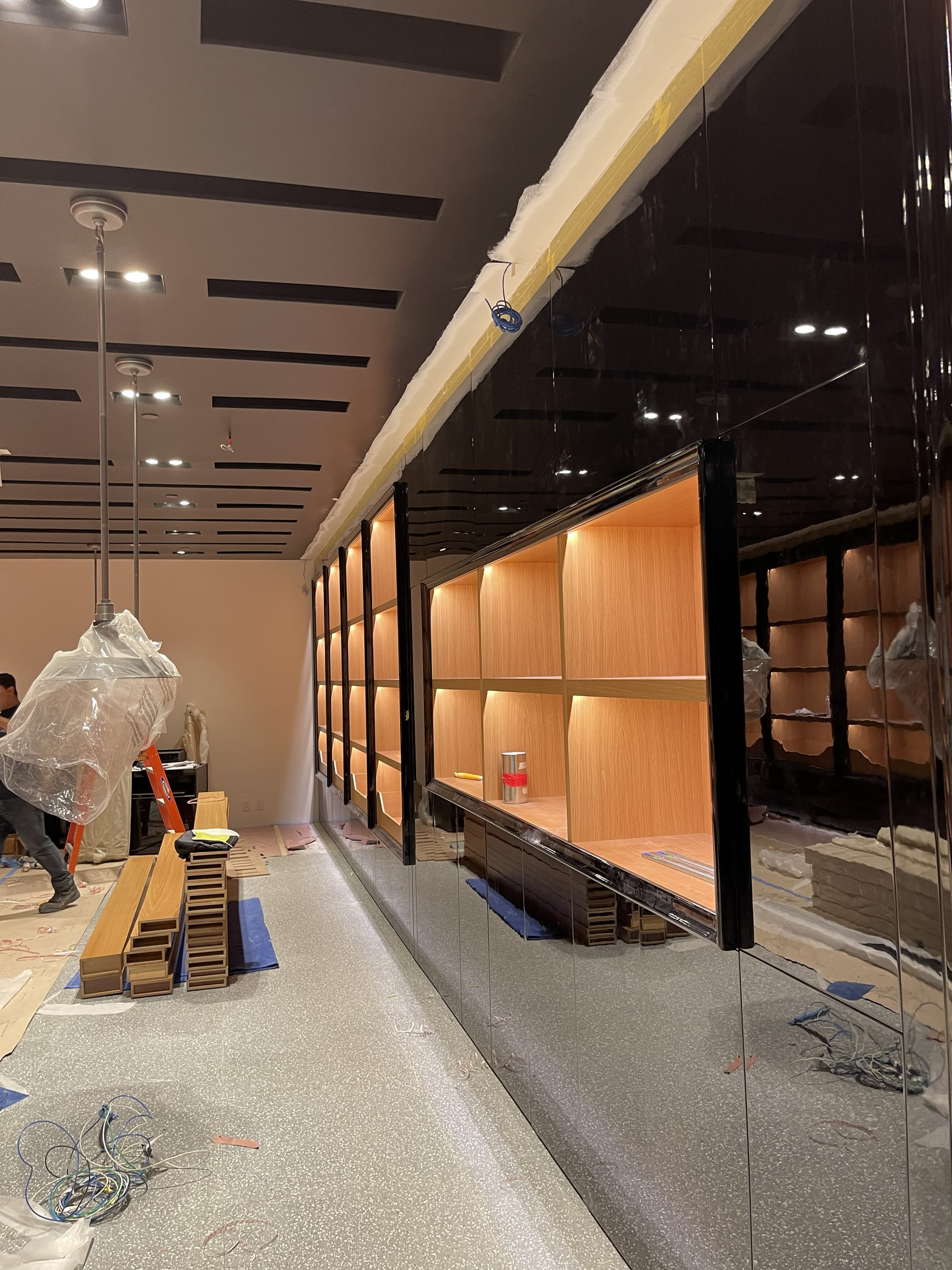 Illuminated display shelving and fixture wall in a finished retail space