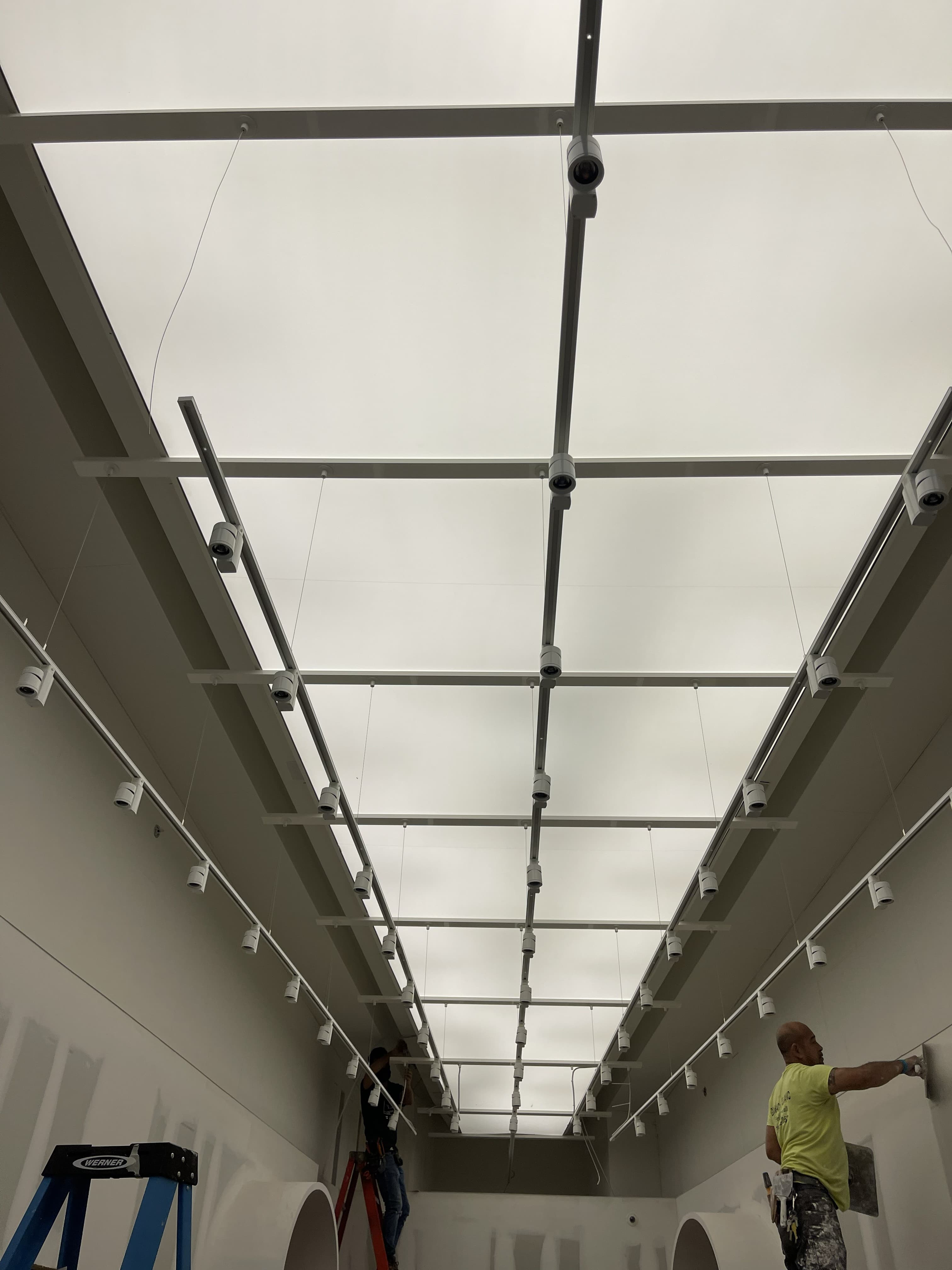 Track lighting fixtures installed and wired into the same ceiling system