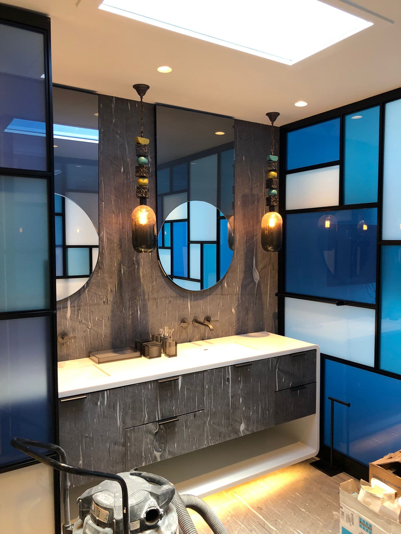 Finished bathroom remodel with decorative pendant lighting, recessed lighting, and integrated vanity illumination