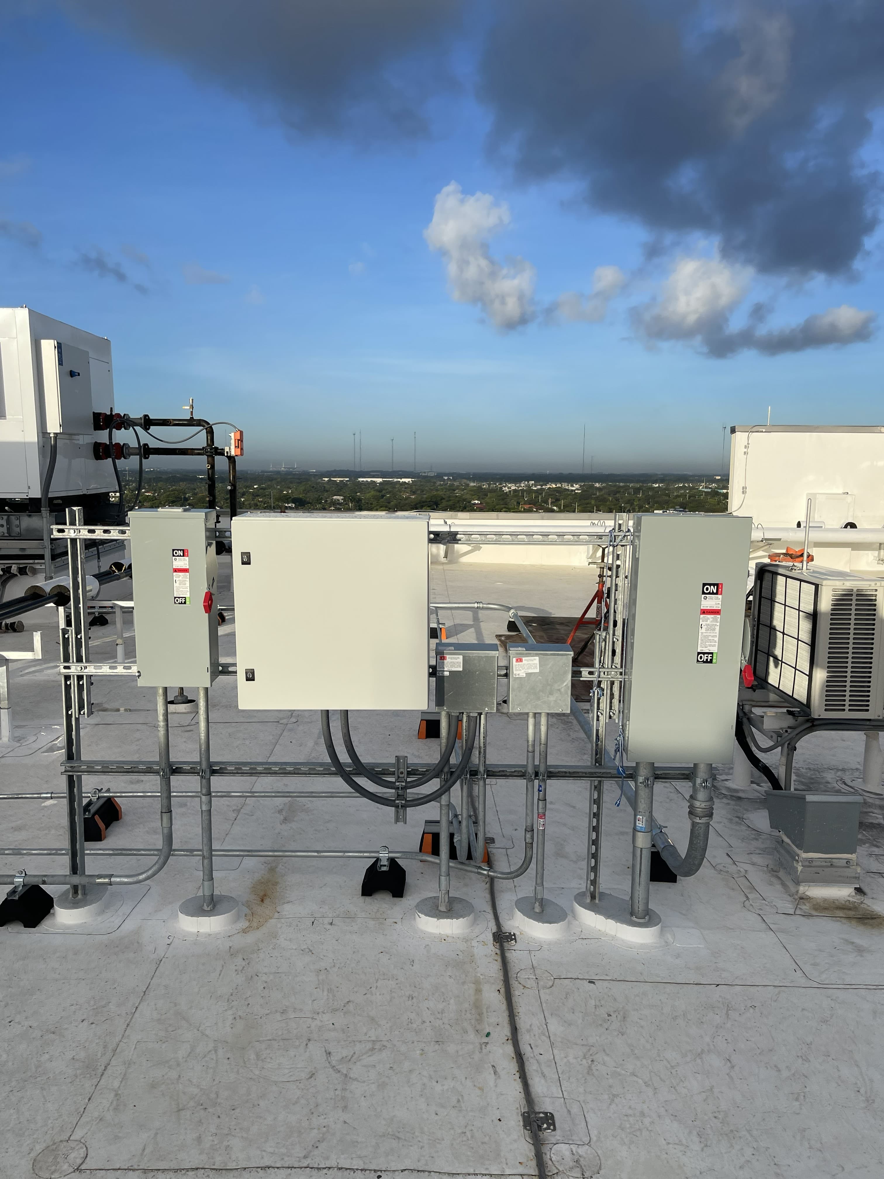 Rooftop electrical disconnect enclosures with a South Florida skyline view